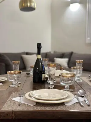 a table with a plate and a bottle of wine at 3Bdr Apartment in the heart of Rome in Rome