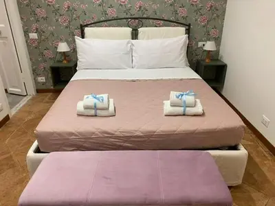 a bedroom with a large bed with two towels at Carrozze apartment in Rome