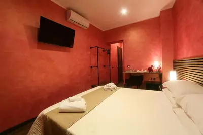 a bedroom with a bed with a tv on the wall at I Quattro Elementi Roma in Rome