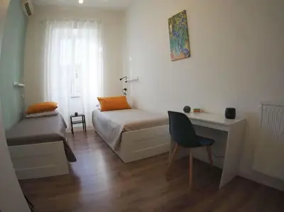 a room with a bed and a desk and a chair at A Casa di Cri in Rome
