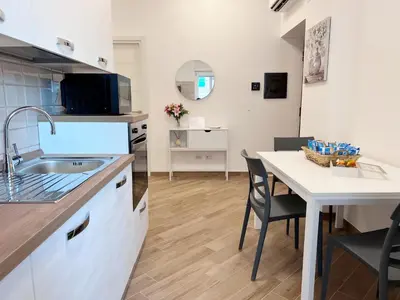 a kitchen with a sink and a table with chairs at Dasy Apartment - San Paolo in Rome