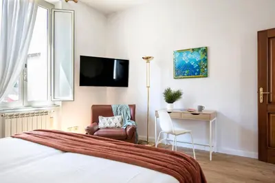 a bedroom with a bed and a chair and a desk at Casa Marchese Lucia in Rome