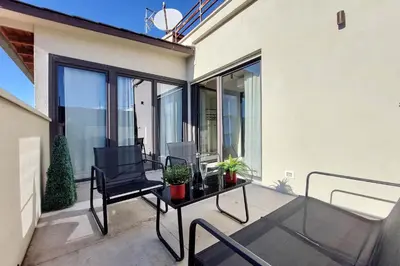 a balcony with a black chair and a table with plants at 100m dal Vaticano Oasi Luxury 2 Terraces in Rome