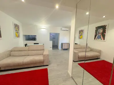 a living room with two couches and a red rug at Mercede Apartment - Spanish Steps in Rome