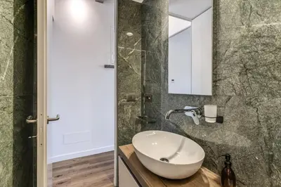 a bathroom with a white sink and a mirror at Piazza dei Renzi Trastevere building 4 bedroom with terrace in Rome