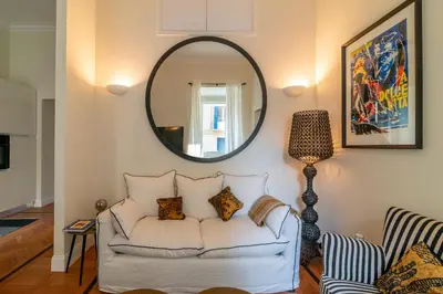 a living room with a white couch and a mirror at Villa Borghese Luxury Place in Rome