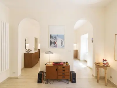 a living room with white walls and a wooden dresser at Apartment Alessandria Home by Interhome in Rome