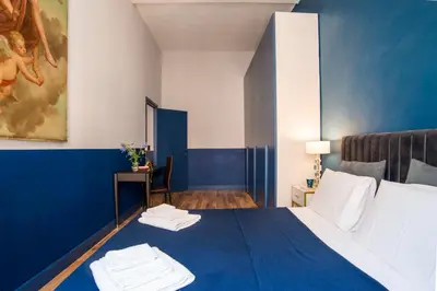a bedroom with a blue and white bed with towels on it at La Trasteverina apartment in Rome