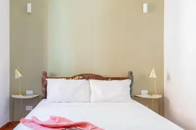 a bedroom with a bed with white sheets and two lamps at iFlat Peaceful brand new 2beds apt in Trastevere in Rome
