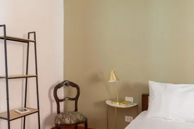a bedroom with a bed and a chair and a lamp at iFlat Peaceful brand new 2beds apt in Trastevere in Rome