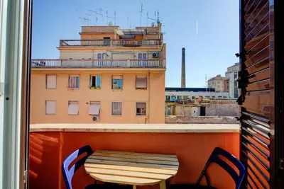 a table and chairs on a balcony with a building at Casetta 79 in Rome