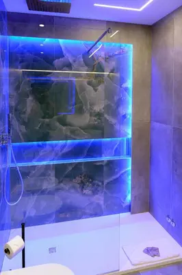 a bathroom with a shower with blue lights at Trastevere golden luxury loft in Rome