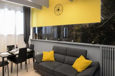 a living room with a couch and a table and a clock at Trastevere golden luxury loft in Rome