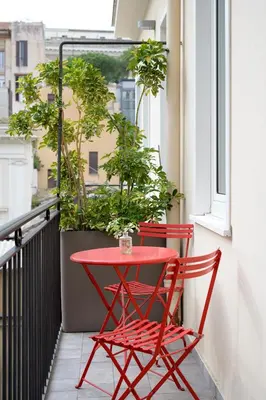 two red chairs and a red table on a balcony at The Fifteen Keys Hotel in Rome
