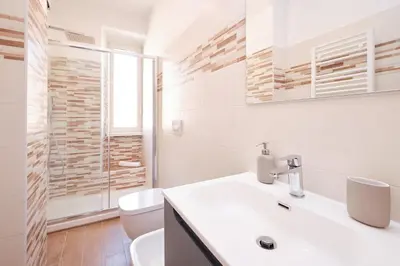 a white bathroom with a toilet and a sink at Elegant Apartment with view of Castel Sant'Angelo in Rome