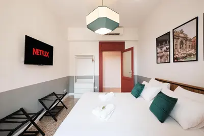 a bedroom with a white bed with green pillows at Elegant Apartment with view of Castel Sant'Angelo in Rome