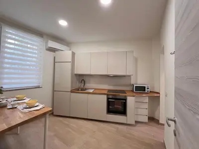 a kitchen with white cabinets and a table and a microwave at Sunshine Eco Residence in Rome