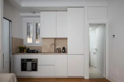 a kitchen with white cabinets and a sink at Monti Zen Penthouse-ZENO57 in Rome