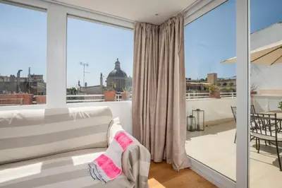 a living room with a couch and a large window at Monti Zen Penthouse-ZENO57 in Rome