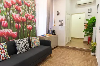 a living room with a couch and red tulips mural at Susy's Guest House Room San Pietro in Rome