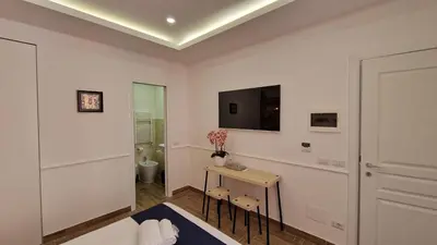 a white room with a toilet and a tv on the wall at Susy's Guest House Room San Pietro in Rome