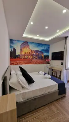 a bedroom with a large bed with a painting on the wall at Susy's Guest House - Room Colosseo in Rome