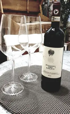 a bottle of wine and two glasses on a table at House Maximo at Colosseum in Rome