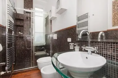 a bathroom with a glass sink and a toilet at House Maximo at Colosseum in Rome