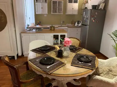 a kitchen with a table with a vase of flowers on it at House Maximo at Colosseum in Rome
