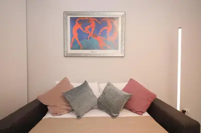 a painting above a couch with pillows on it at Rome Flat 42 by GHOR in Rome