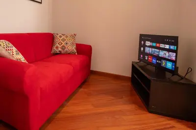 a red couch in a living room with a flat screen tv at Pigneto Holiday in Rome
