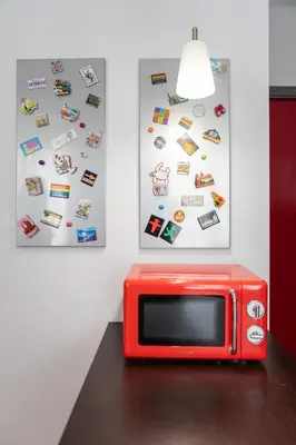 a red microwave sitting on a table next to two pictures at Pigneto Holiday in Rome
