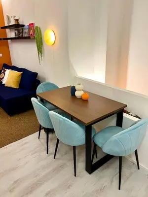 a dining room table with blue chairs and a couch at Charming Navona - The Loft in Rome
