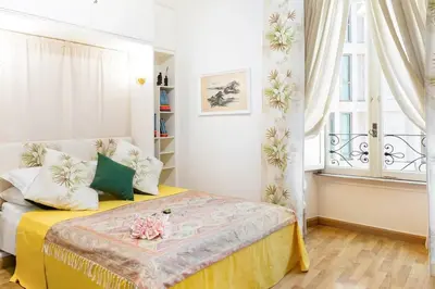 a bedroom with a bed with a yellow blanket and a window at Appartamento elegante Castel Sant'Angelo in Rome