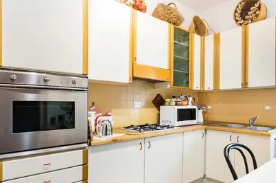 a kitchen with white cabinets and a stove top oven at Appartamento elegante Castel Sant'Angelo in Rome