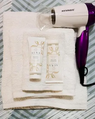 a hairdryer and two products on a towel at Richard & Lulù in Rome in Rome