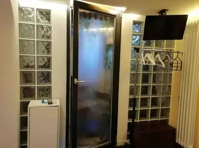 a walk in closet with a glass door and a television at Little gem in Trevi Fountain in Rome