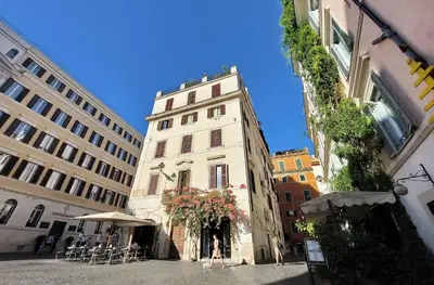 a tall white building with people walking in front of it at Monti in Rome