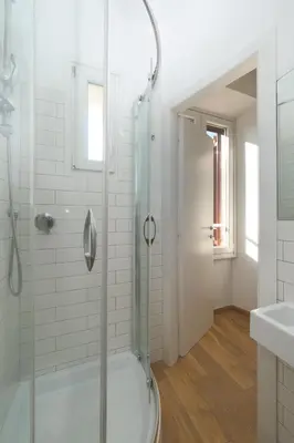 a white bathroom with a shower and a sink at Elena's Apartment - Piramide Metro Station in Rome