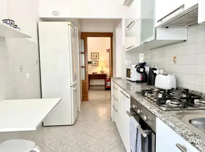 a white kitchen with a sink and a stove at 10 minuti da stazione Trastevere in Rome