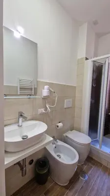 a bathroom with a sink and a toilet and a mirror at Susy's Guest House - Room Spagna in Rome