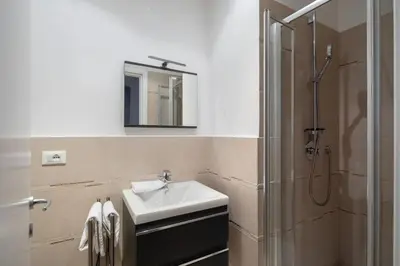 a bathroom with a sink and a shower with a mirror at New apartment near Piazza del Popolo in Rome