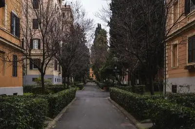 an empty street in a city with trees and buildings at New apartment near Piazza del Popolo in Rome
