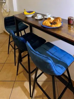 a table with blue chairs and a plate of bread at Romeantique in Zama in Rome
