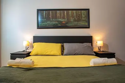 a bedroom with a large bed with two lamps at Locazioni Ostiense - Joy House in Rome