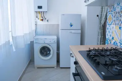 a kitchen with a washing machine and a refrigerator at San Paolo GreenHouse in Rome
