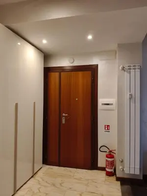 a hallway with a wooden door in a building at Roma Eur - OrangeVibes Loft in Rome