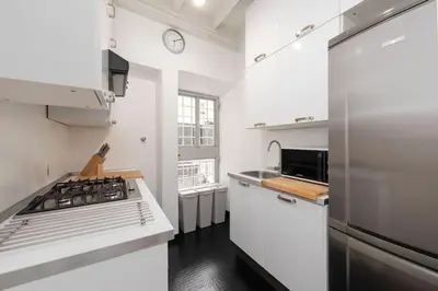 a white kitchen with a stove and a sink at My Spanish Steps Apartment - 2 bathrooms in Rome
