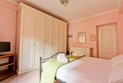 a small bedroom with a bed and a tv at Suite Porta Portese in Rome