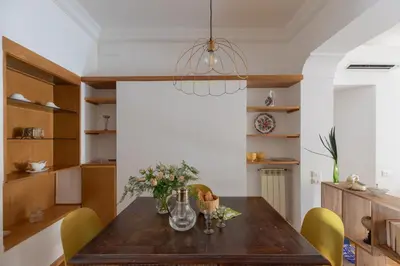 a dining room with a wooden table and yellow chairs at iFlat Pantheon Peaceful & Comfortable Apartment in Rome